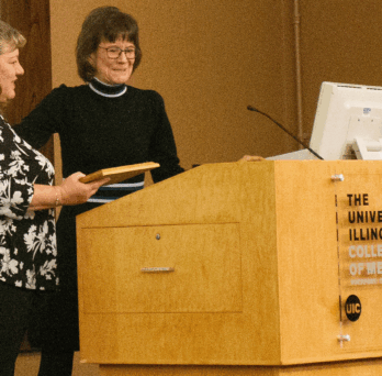 Diane Potts, UICOMR assistant director of curriculum outreach and development, gives Kristen Green, MD, the 2022 Rural Health Hero Award. 