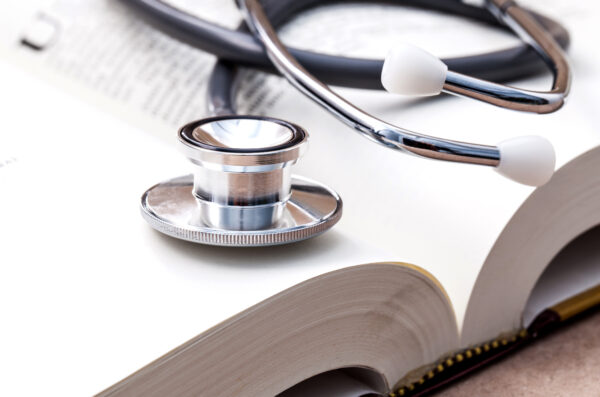 A stethoscope rests on an open book