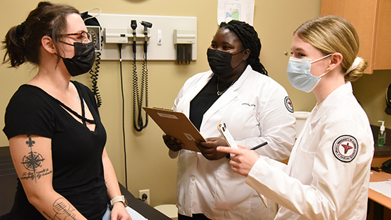 Two undergraduate medical students talking with a patient