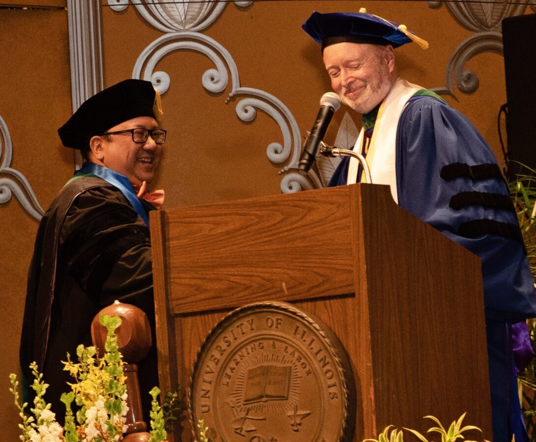 Raymond Garcia, MD, accepts the Distinguished Service Award from Dean Stagnaro-Green during the Convocation Ceremony.