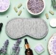 gray eye mask with  dried lavender on green background