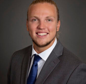 William Fox in blue tie, white shirt and dark blazer. 